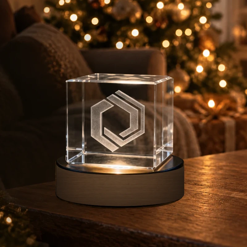 Cube de cristal gravé avec un monogramme sur socle lumineux